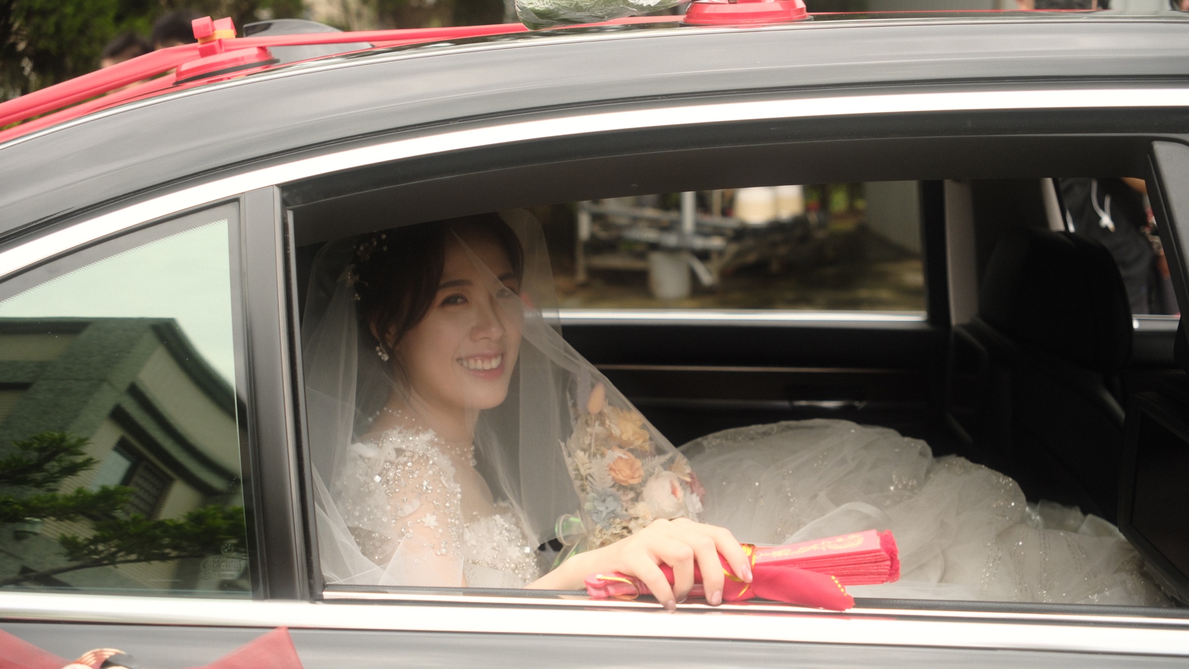 坐在汽車後座微笑的新娘